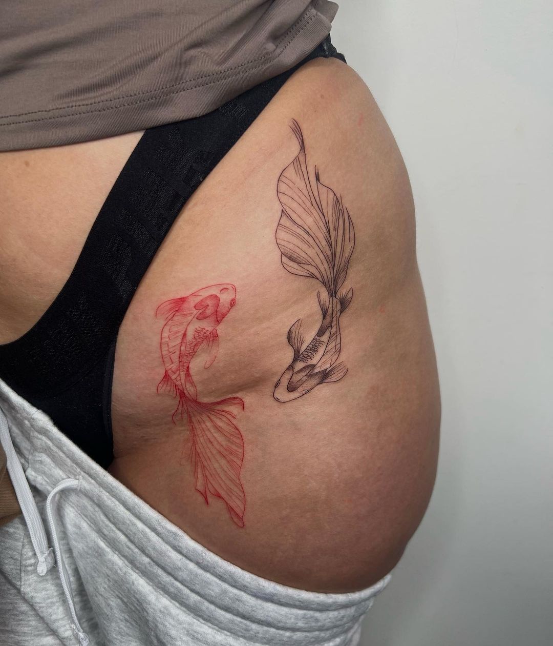 Koi Fish Tattoo Flowing Onto The Thigh