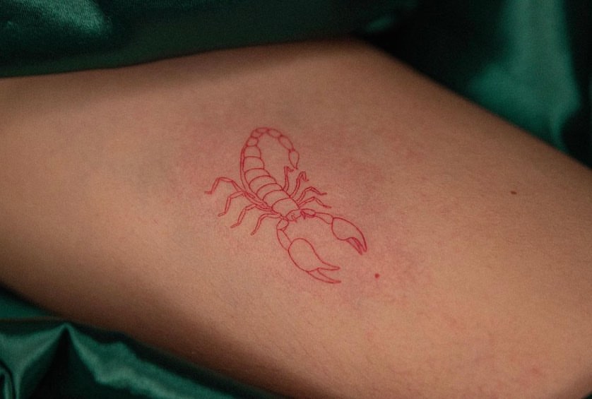 Minimalist Red Ink Scorpion Forearm Tattoo