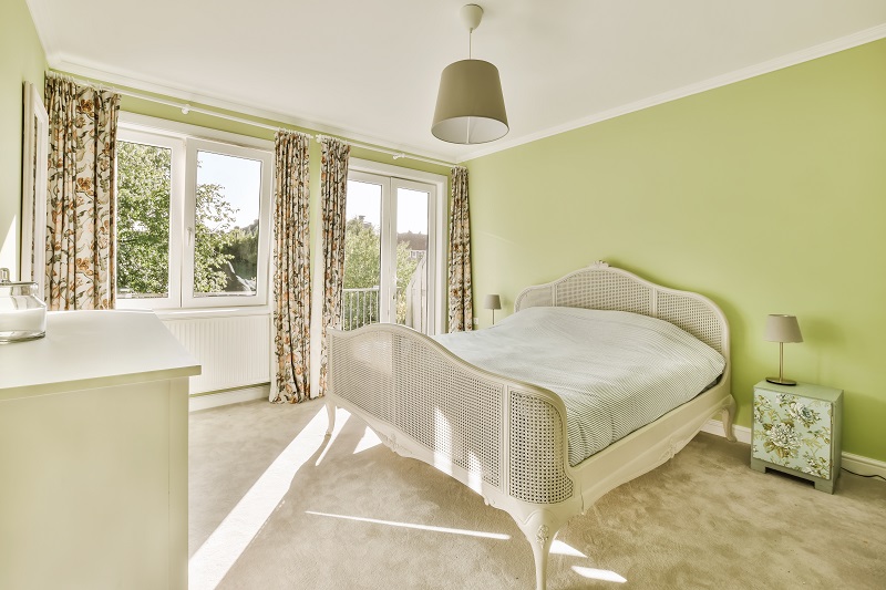 A,bedroom,with,green,walls,and,white,furniture,in,the