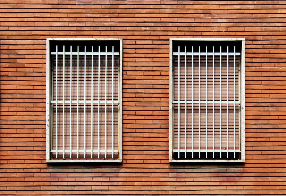 Window,bars,and,closed,windows,on,a,bricks,wall